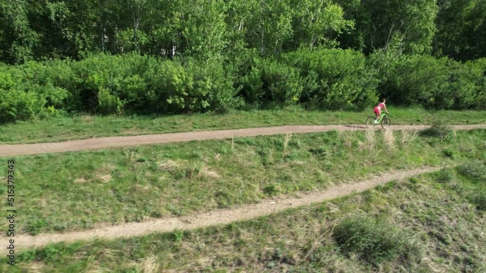 Beautiful athletic woman riding a bike, aerial shot Beautiful athletic woman riding a bike, aerial shot