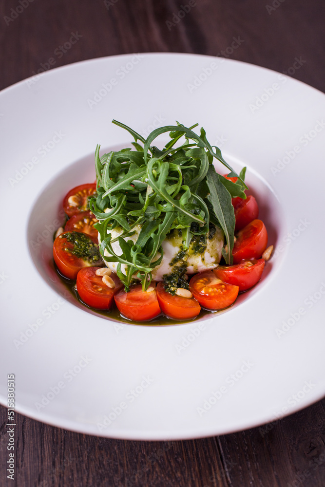 Salad with tomatoes, arugula, mozzarella and sauce Salad with tomatoes, arugula, mozzarella and sauce