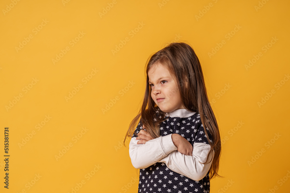 cute little Caucasian girl of 5 years old, insulted and offended on a yellow background. The baby is tired, capricious and turns away. Does not make contact. Close-up cute little Caucasian girl of 5 years old, insulted and offended on a yellow background. The baby is tired, capricious and turns away. Does not make contact. Close-up