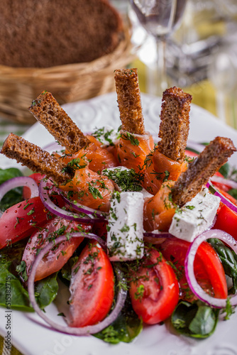 Salad with mozzarella, tomato, pepper, salmon, croutons, lettuce, basil, parsley