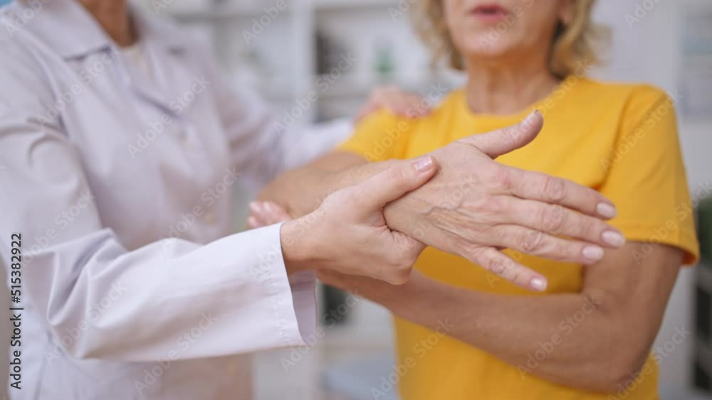 Rehabilitation expert helping patient stretch arm muscles after injury treatment