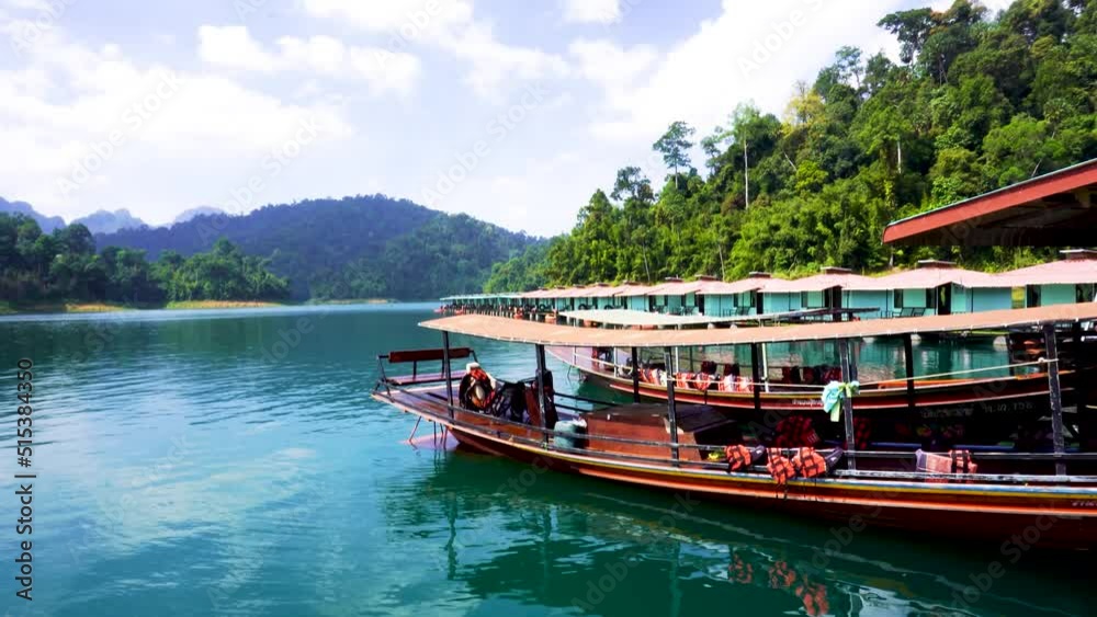 View Of Traditional Longboats Moored At Pier On Cheow lan lake Located In Khao Sok National Park. Handheld Pan Up Shot View Of Traditional Longboats Moored At Pier On Cheow lan lake Located In Khao Sok National Park. Handheld Pan Up Shot