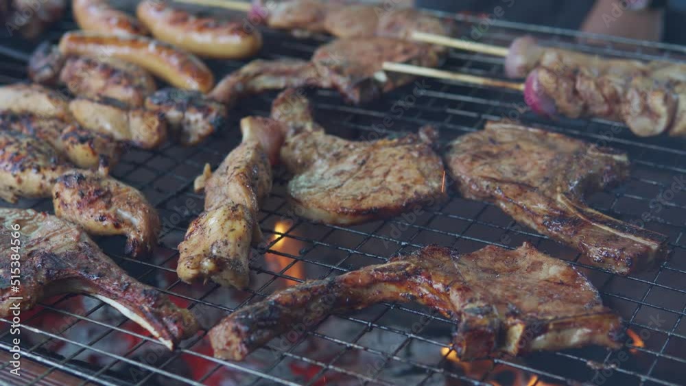 A cinematic shot of grilled beef and chicken barbecue on gridiron during family party. A cinematic shot of grilled beef and chicken barbecue on gridiron during family party.