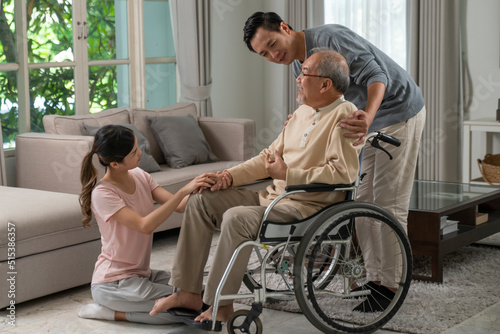 Young asian man, woman and old asian man with wheelchair at home