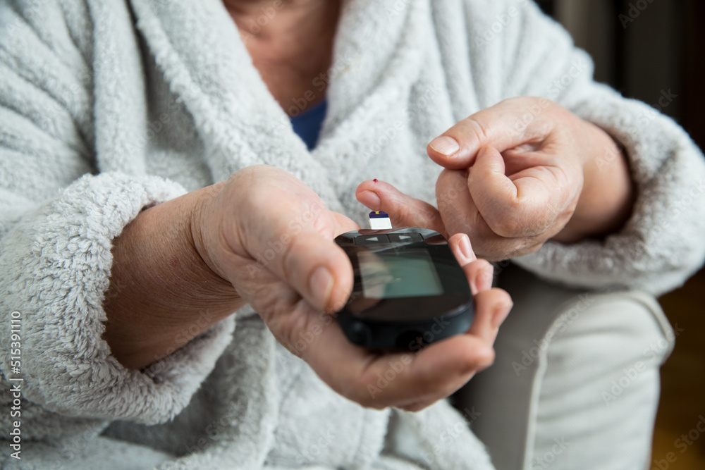 Senior woman checking blood sugar level using home Closeup