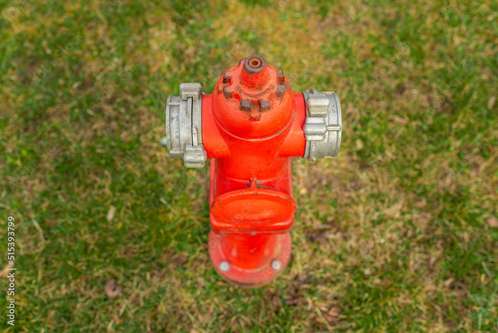 Single red fire hydrant on green lawn.Autumn,spring,summer day.Copy space.Top view. Single red fire hydrant on green lawn.Autumn,spring,summer day.Copy space.Top view.
