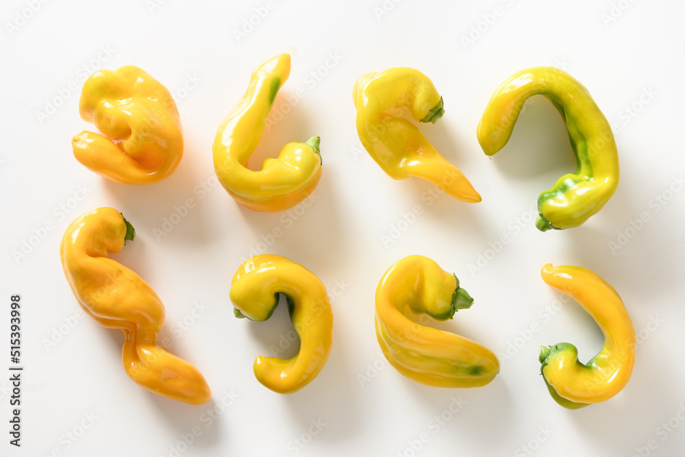 Food pattern of ugly organic yellow pepper on white background. View from above. Flat lay. Food pattern of ugly organic yellow pepper on white background. View from above. Flat lay.
