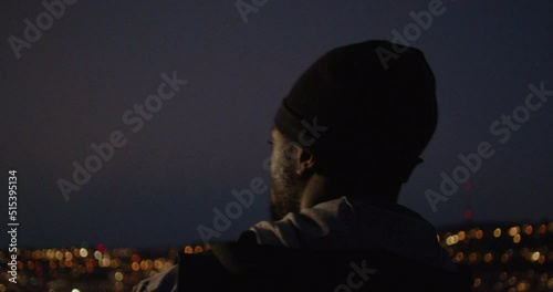 Young black man stopping during his run to admire city light during blue hour in the South of Germany. photo