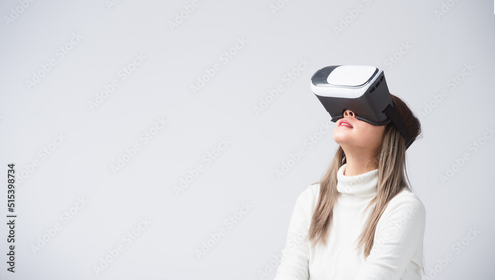 Amazed asia woman in virtual reality, using vr glasses headset, standing over white background Amazed asia woman in virtual reality, using vr glasses headset, standing over white background