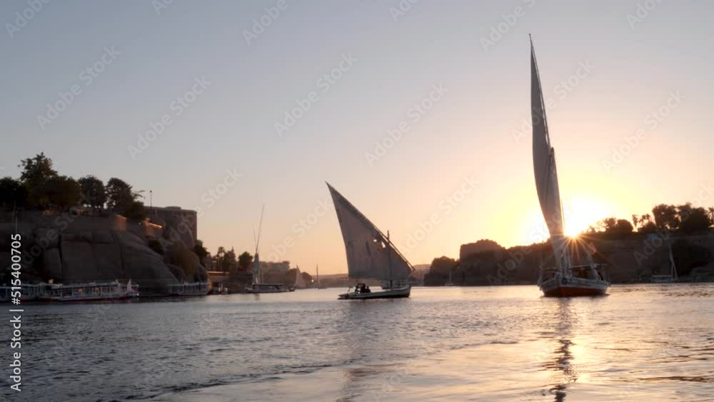 View of two feluccas during sunset sailing on the Nile river in Aswan, Egypt. View of two feluccas during sunset sailing on the Nile river in Aswan, Egypt.