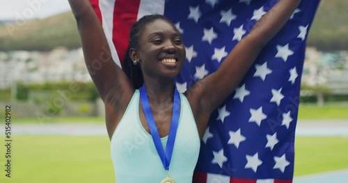 Proud and patriotic african american athlete celebrating with a USA flag after becoming a champion. Olympic gold medalist and professional sportswoman cheering with a medal after winning a race photo