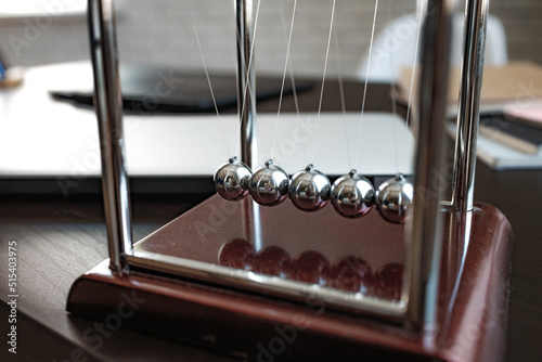 Newton's cradle balls on the wooden table in office