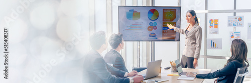 An Asian businesswomen is presenting his company performance report to his boss or group of male and female colleagues with confidence and professionalism web banner with copy space on left