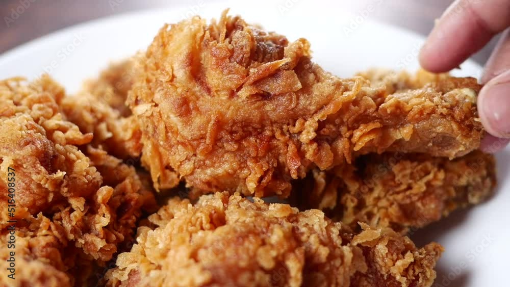 slow motion of hand pick Crispy fried chicken wings on a plate 