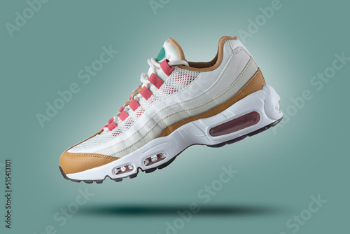 White sneaker with colored accents on a green gradient background, men's fashion, sport shoe,  air, sneakers, lifestyle, concept, product photo,  levitation concept, street wear, trainer
