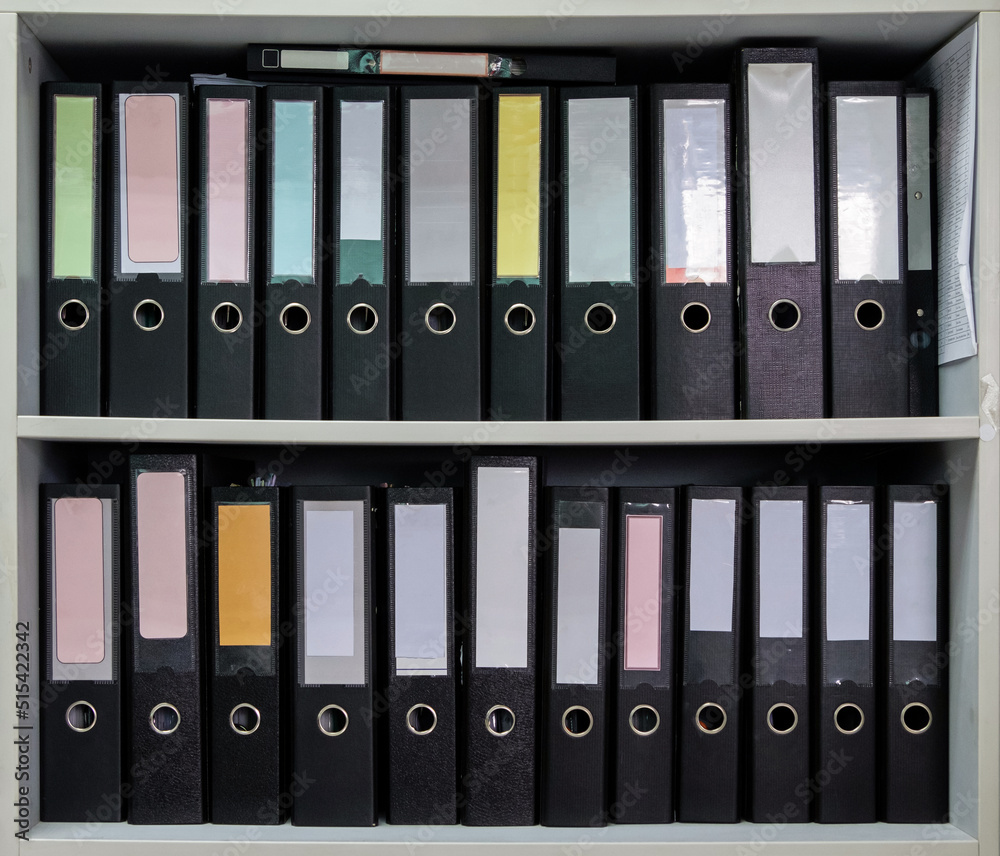 Closeup of the black plastic folder are rowing in the white shelf. Closeup of the black plastic folder are rowing in the white shelf.