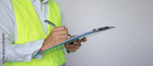 Construction worker inspector checking notes in clipboard, Engineer checking and inspecting with clipboard at indoor construction site construction inspection, contractor and engineering concept