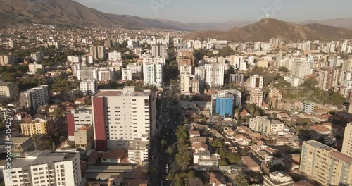 avenida en ciudad con edificios parques cerros drone