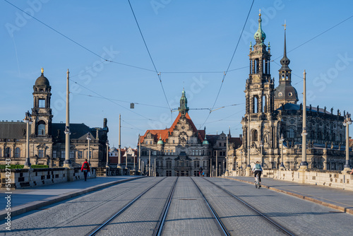 Dresden Blick über die menschenleere Augustusbrücke am frühen Morgen, einige Fußgänger und Radfahrer passieren