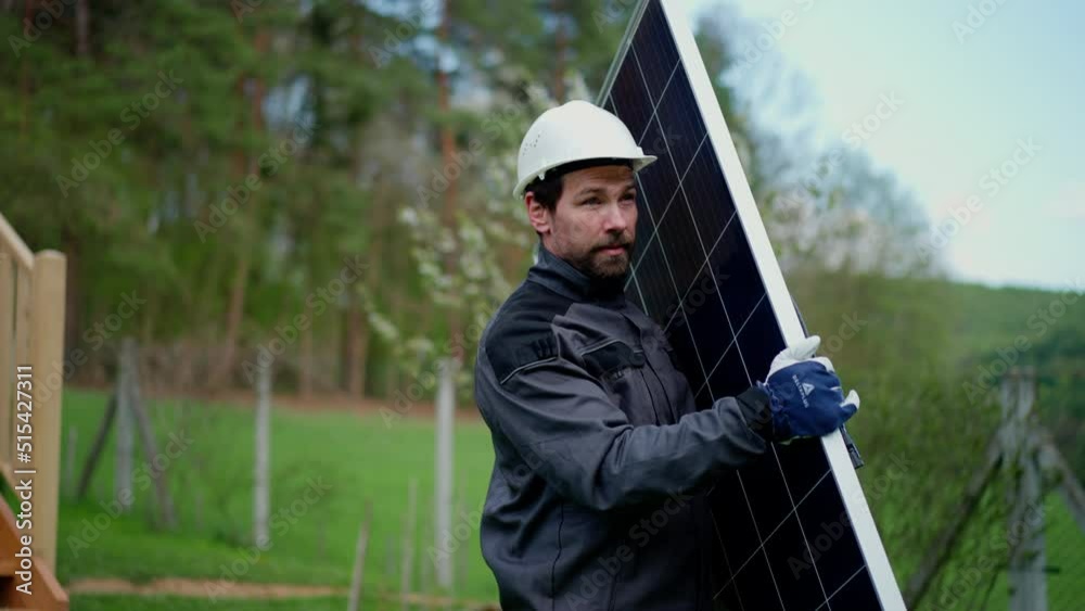 Man worker carrying solar panel for installing solar modul system on house.