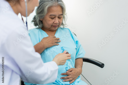 Physician examining heart with a stethoscope and talking with a senior woman at a clinic for check yearly checkup, Medicine health care service and medical insurance concept.