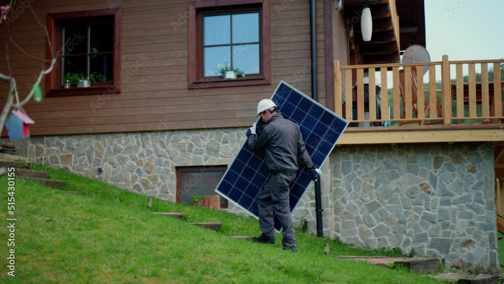 Man worker carrying solar panel for installing solar modul system on house.
