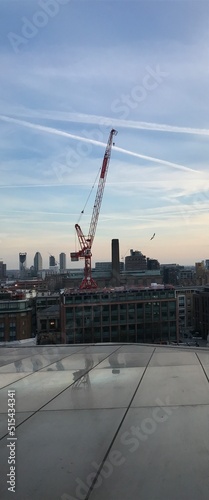 London skyline at sunset with landmark buildings and construction cranes. 