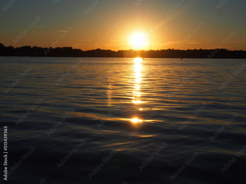 Obraz premium Lake Sunset Reflecting on Pontoon Boat