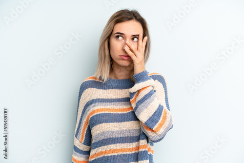 young adult pretty woman feeling bored, frustrated and sleepy after a tiresome, dull and tedious task, holding face with hand