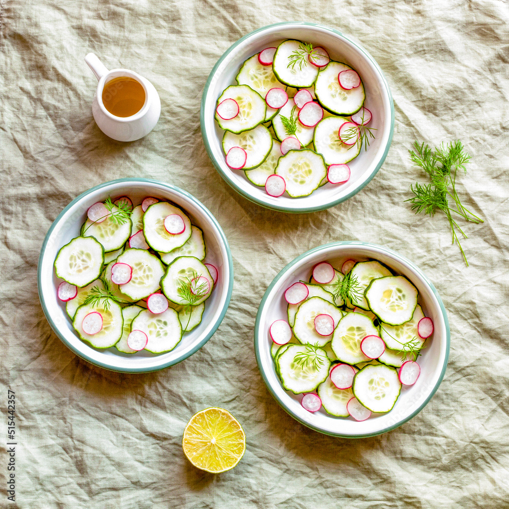Three small round bowls with radish and cucumber summer light salad