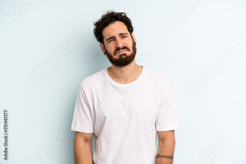young adult bearded man feeling sad and whiney with an unhappy look, crying with a negative and frustrated attitude