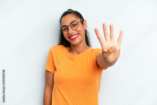 hispanic pretty woman smiling and looking friendly, showing number four or fourth with hand forward, counting down photo