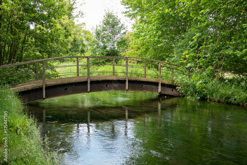 rustic wooden and metal bridge over a beautiful chalk river in Hampshire England