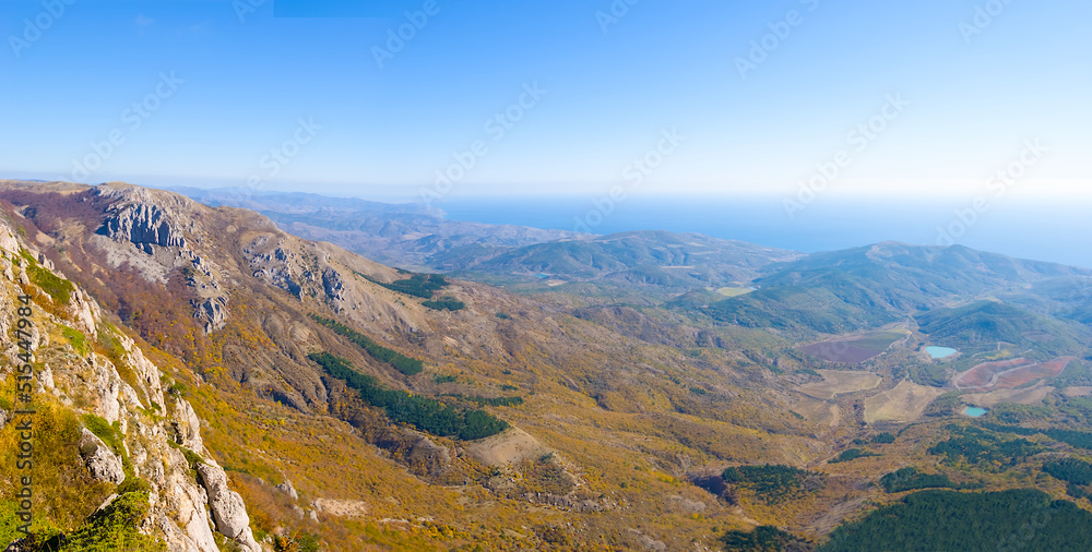 view from mountain ridge to valley under blue sky view from mountain ridge to valley under blue sky
