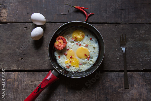 Scrambled eggs in a frying pan on a wooden background. Selective focus.