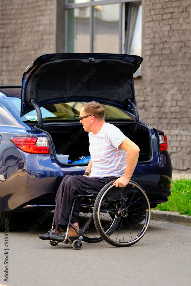 person in a wheelchair near his car person in a wheelchair near his car