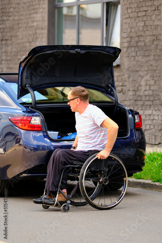 person in a wheelchair near his car © Alex