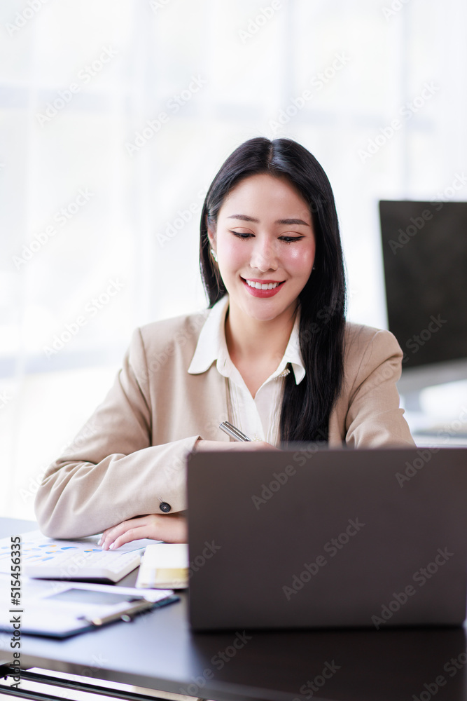 Asian Businesswoman working on laptop at the office with documents on his desk, doing planning analyzing the financial report, business plan investment, finance analysis concept Asian Businesswoman working on laptop at the office with documents on his desk, doing planning analyzing the financial report, business plan investment, finance analysis concept