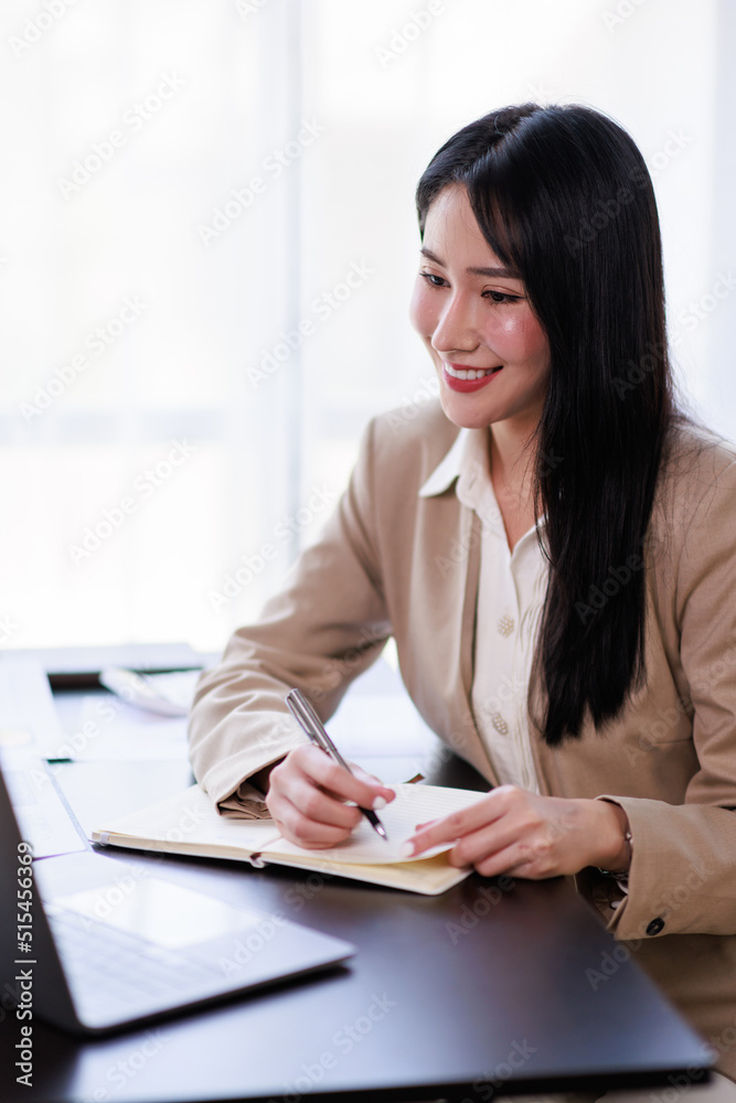 Asian Businesswoman working on laptop at the office with documents on his desk, doing planning analyzing the financial report, business plan investment, finance analysis concept Asian Businesswoman working on laptop at the office with documents on his desk, doing planning analyzing the financial report, business plan investment, finance analysis concept