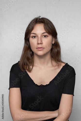 Portrait of a beautiful natural young woman in a black t-shirt. She is looking at the camera, a neutral expression.