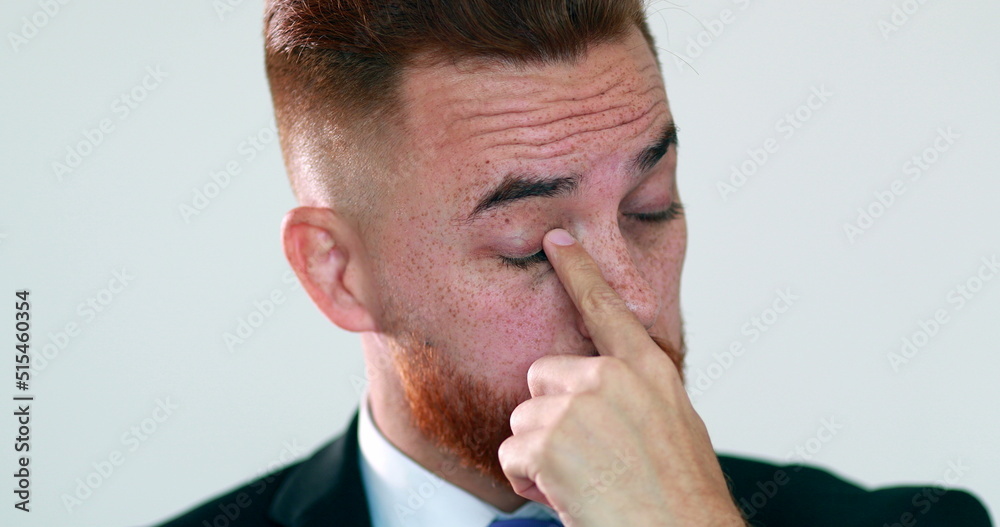 Fototapeta premium Pensive man touching face with hand. Thinking business person rubbing eye with finger