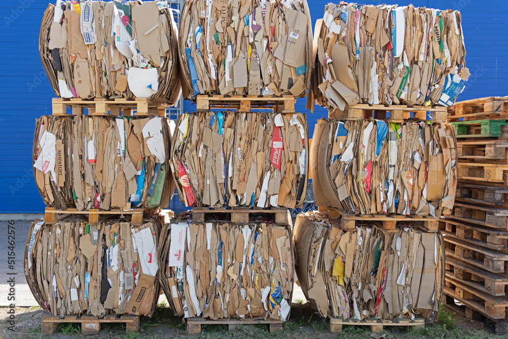 Pressed cardboard warehouse - boxes and packaging from goods, garbage is stored on wooden pallets