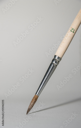 a thin needle brush writes on the blank white paper