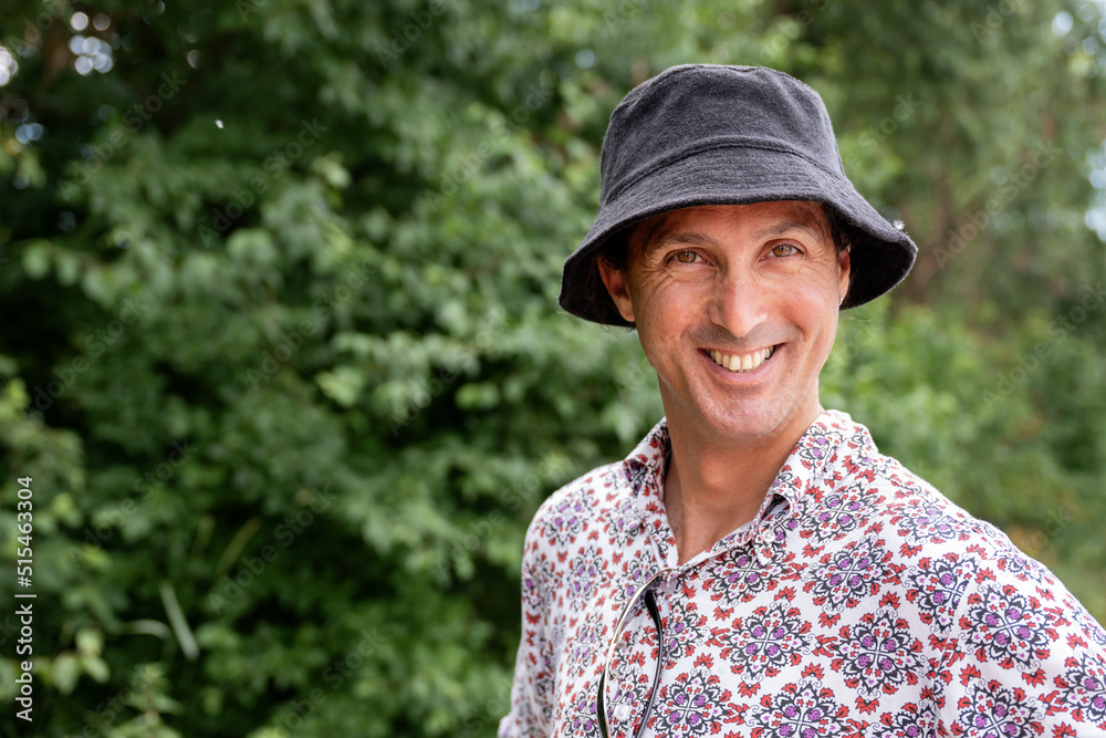 Smiling man in a hat in a garden Smiling man in a hat in a garden