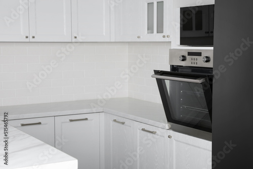 Modern oven and microwave in white clean kitchen