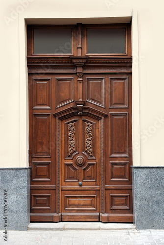 Entrance of house with beautiful wooden door and transom window