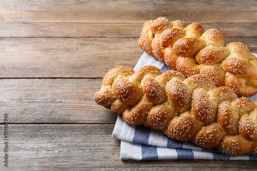 Bild auf Leinwand Homemade braided breads with sesame seeds on wooden table, space for text
