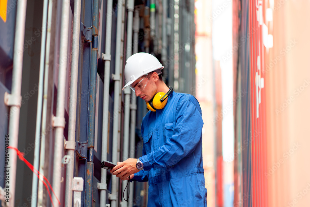 Cargo container with blue collar and safety protection uniform use barcode scaner to check product and stay between stack of the tanks in workplace area.