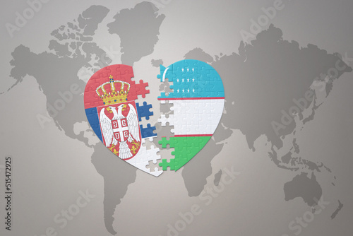 puzzle heart with the national flag of uzbekistan and serbia on a world map background.Concept.