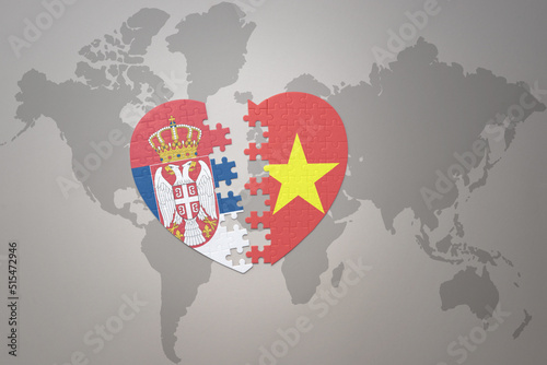 puzzle heart with the national flag of vietnam and serbia on a world map background.Concept.